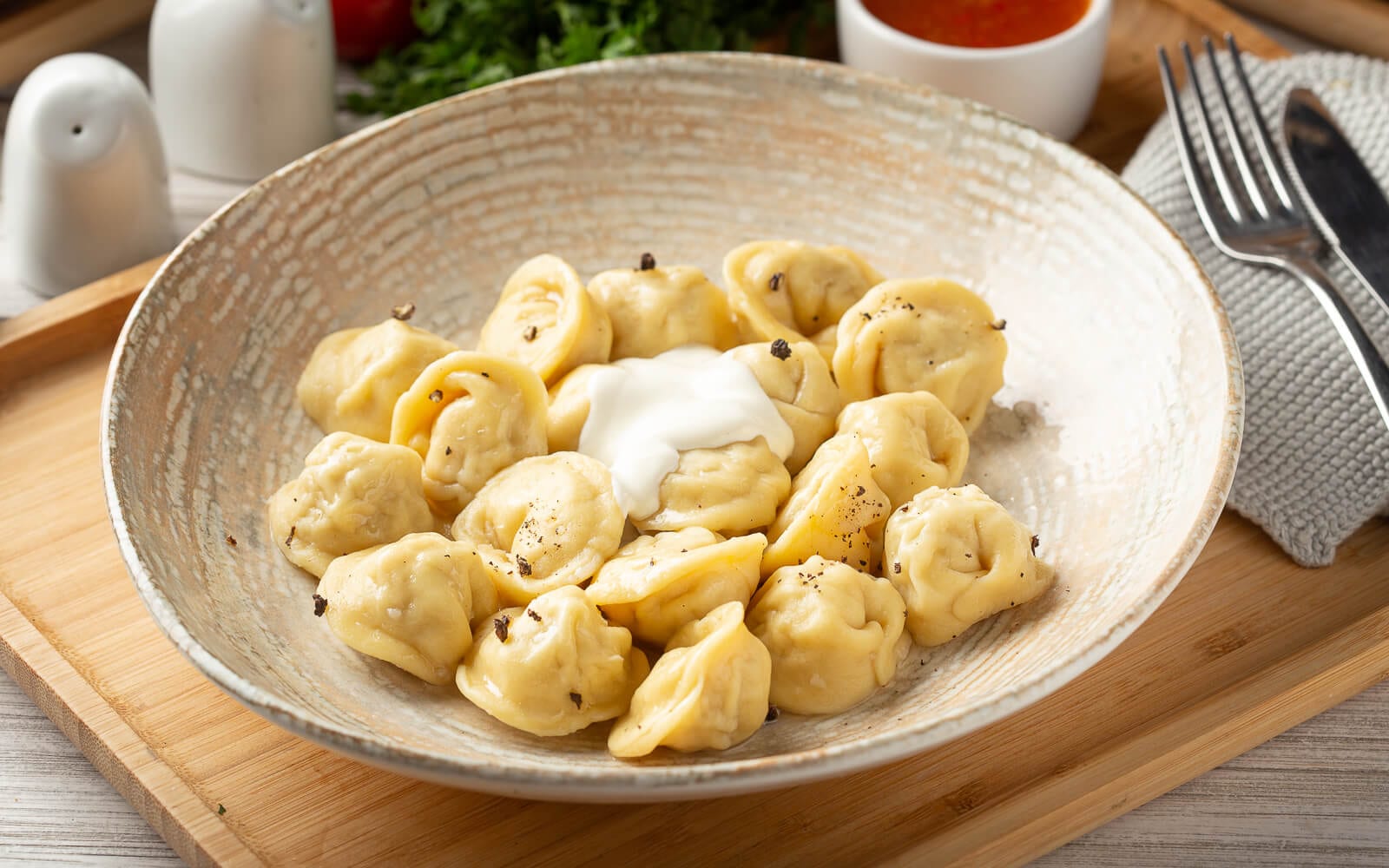Homemade pelmeni with sour cream